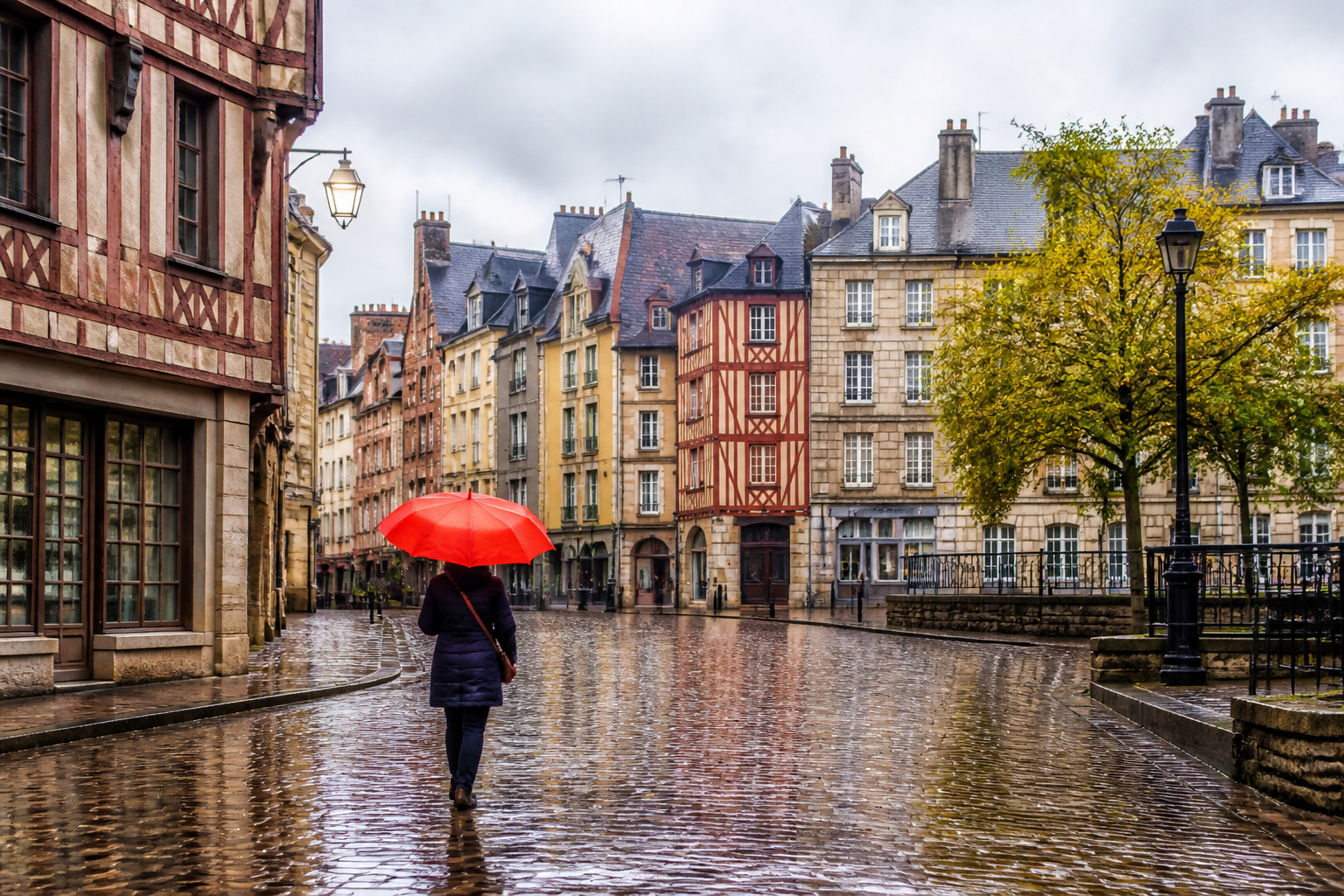 Rue pluvieuse a rennes avec parapluie rouge